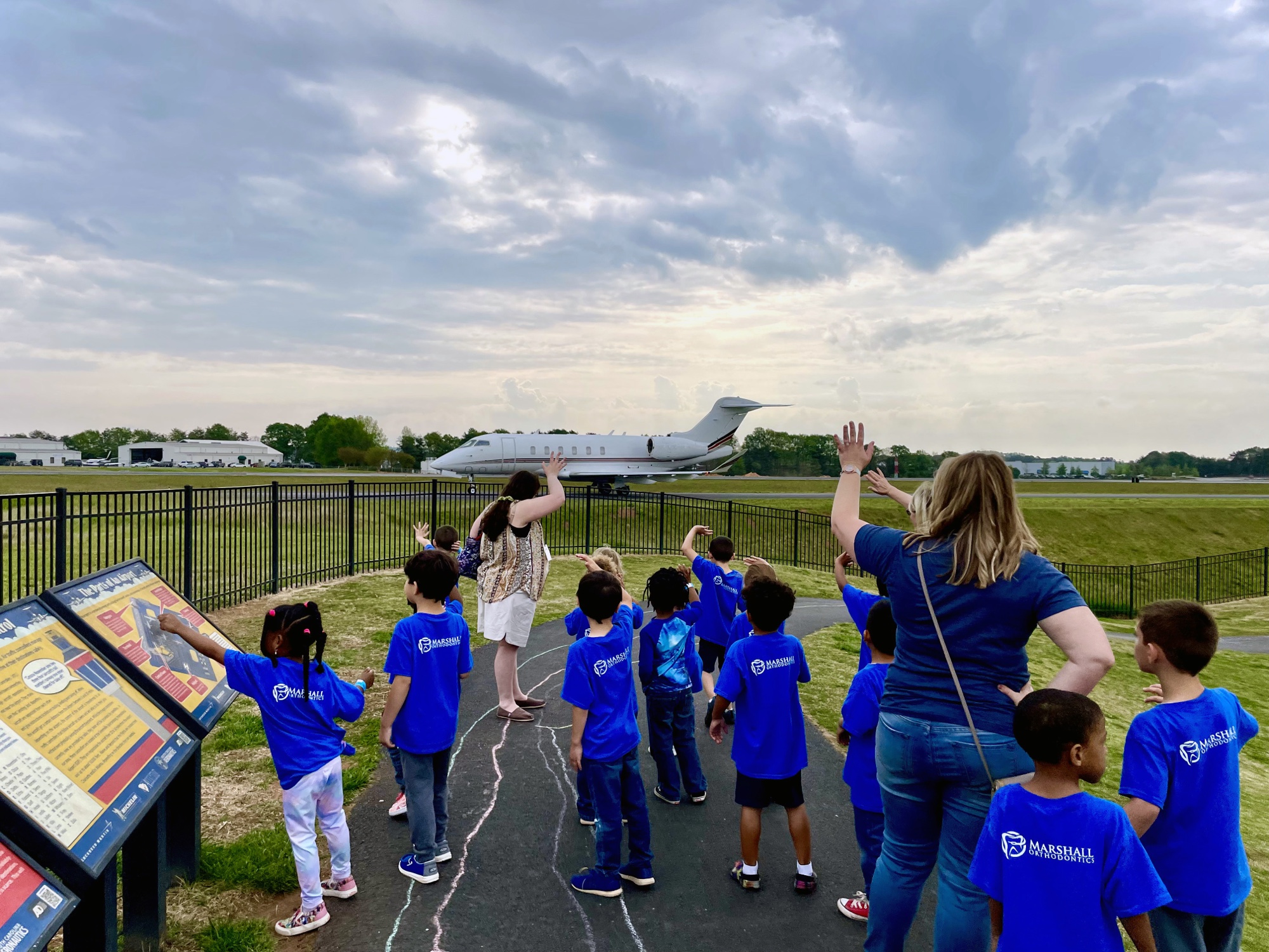 Students watching an aircraft taxi from the Community Corridor